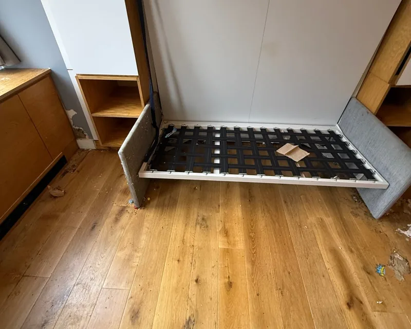 The wall bed folded down, droppings throughout the frame and panels
